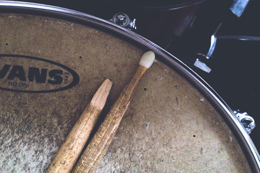 Close-up of worn drumsticks on a vintage drum head