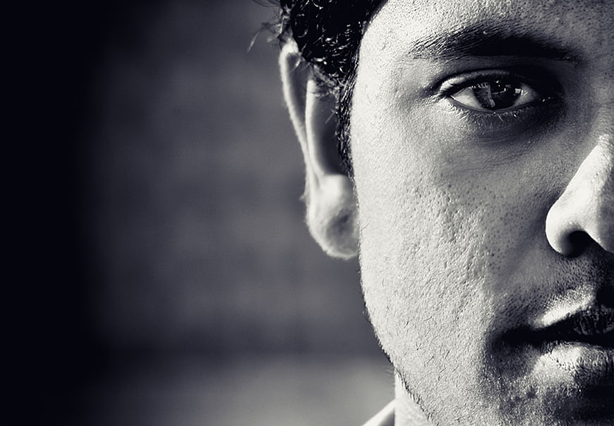 Black and white close-up of a man's eye and profile