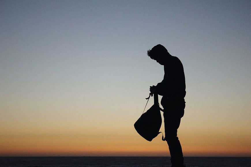 Silhouette of Man with Bag at Sunset