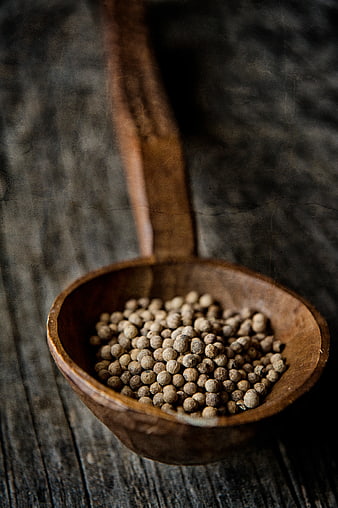 White Peppercorns in a Rustic Wooden Spoon on Dark Wood