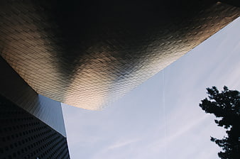 Low angle view of modern textured building facade against sky