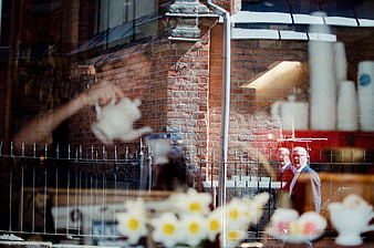 Cafe window reflection with street scene and flowers