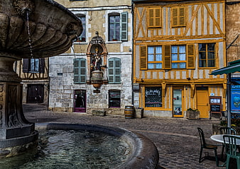Historic European Town Square With Stone Fountain And Half-Timbered Buildings
