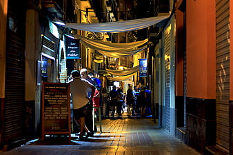 Nightlife in a narrow European alley with people dining