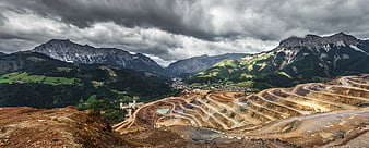 Panoramic view of open-pit mine in mountain valley