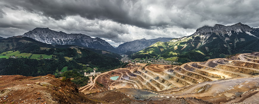 Panoramic view of open-pit mine in mountain valley