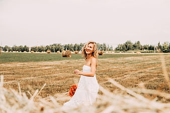 Happy Bride in White Dress Walking Through Harvested Field
