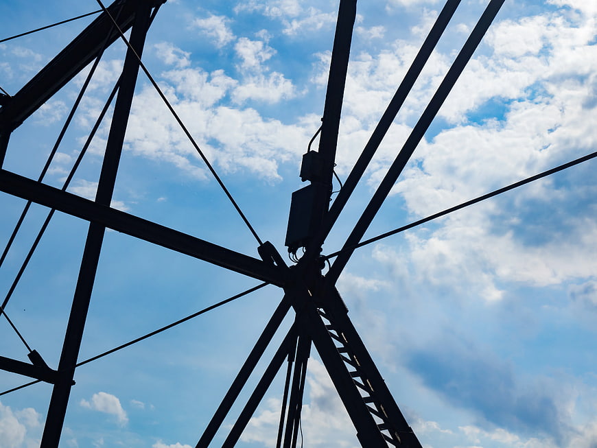 Silhouette of Steel Bridge Structure Against Blue Sky