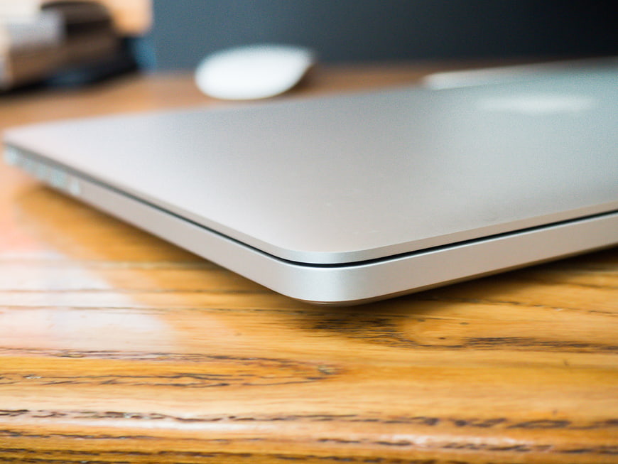 Close-up of closed silver laptop on wooden desk