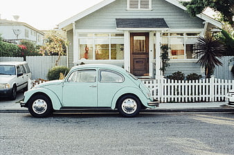 Vintage mint green Volkswagen Beetle parked on suburban street