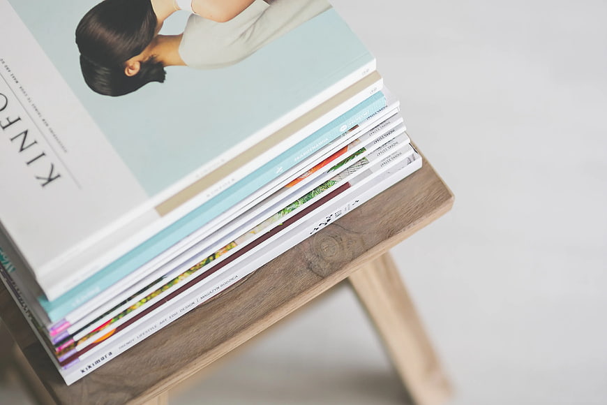 Stack of design magazines on wooden stool with copyspace