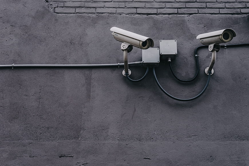 Two CCTV Security Cameras Mounted on Textured Gray Concrete Wall