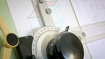 Close-up of vintage drafting machine on architectural blueprint