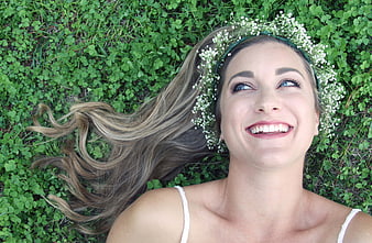 Happy Woman with Flower Crown Lying in Green Grass