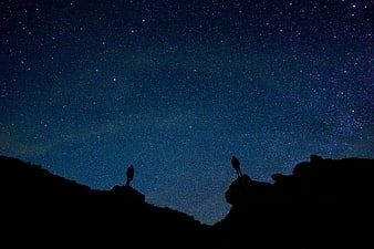 Silhouettes of Hikers Under Starry Night Sky