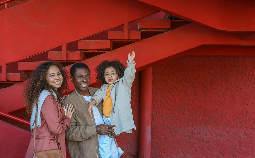 Happy African American Family Portrait in Front of Red Stairs
