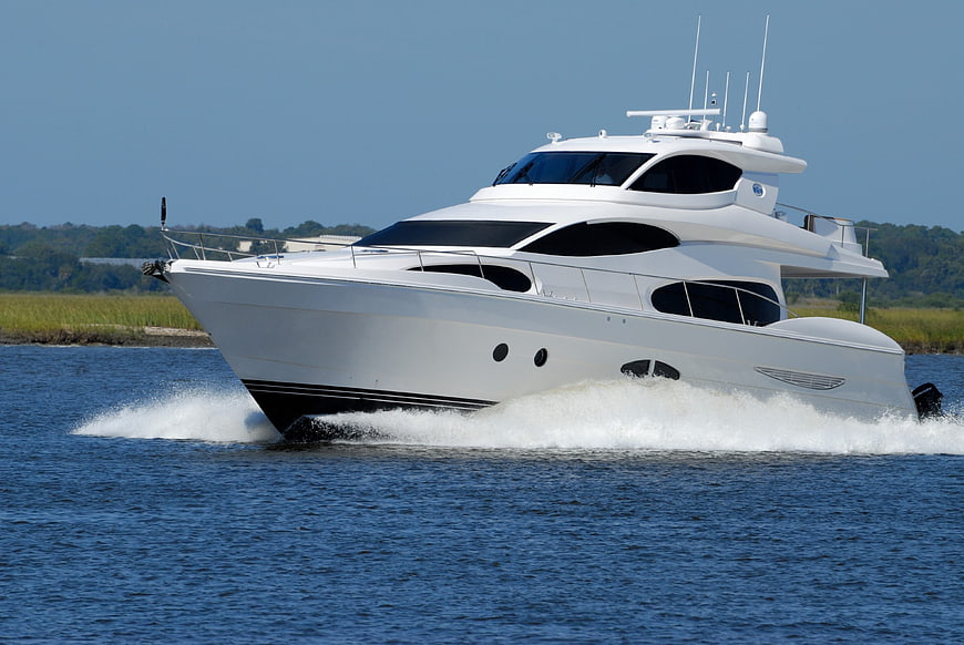 White luxury yacht speeding across blue water