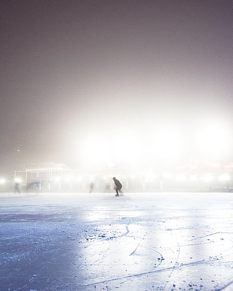 Ice Skater on Foggy Rink at Night