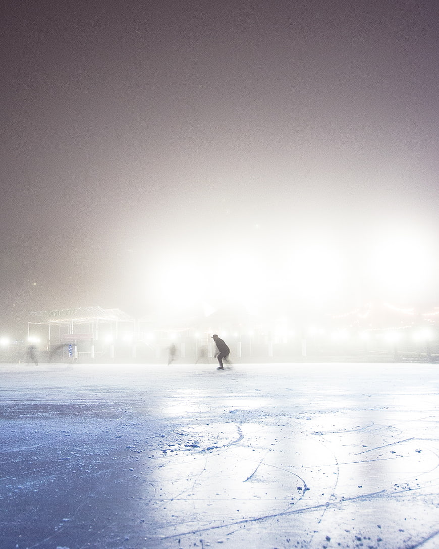 Ice Skater on Foggy Rink at Night