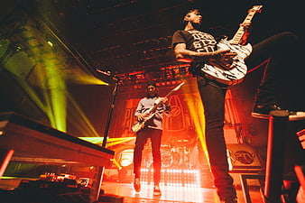 Rock band performing live on stage with electric guitars