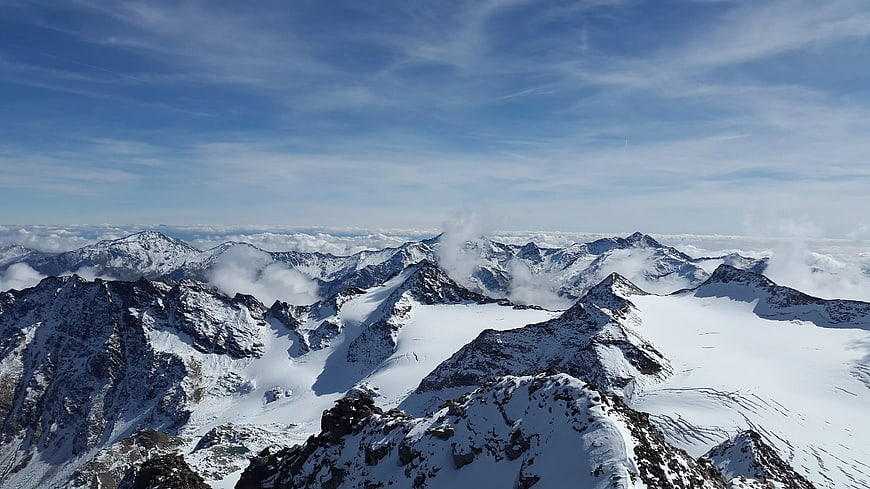 Snow-Covered Mountain Peaks Above Clouds