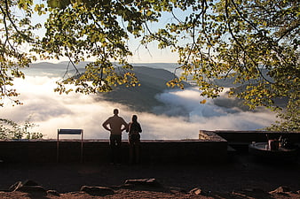 Couple Silhouetted Against Morning Mist and Mountain Landscape