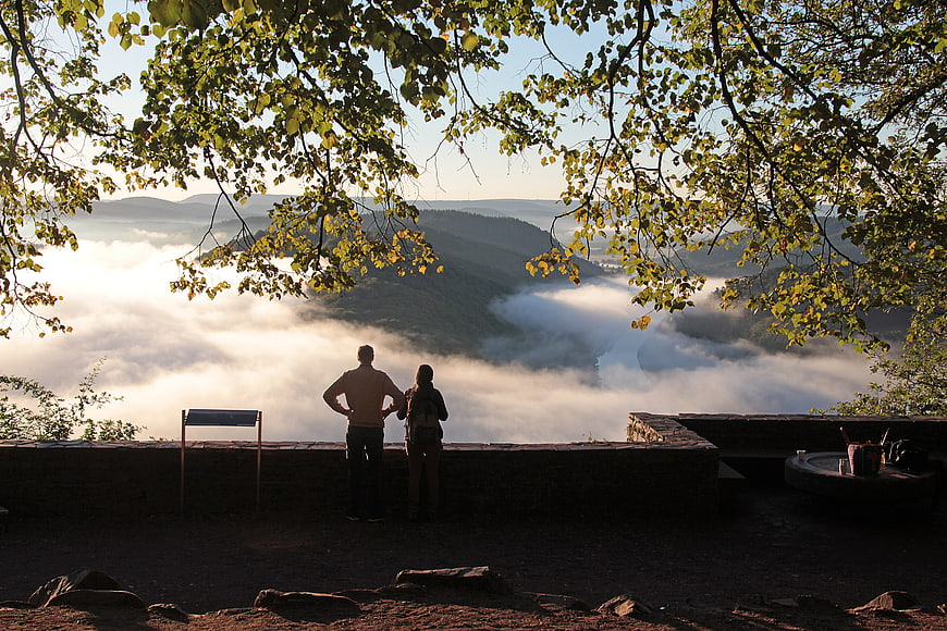 Couple Silhouetted Against Morning Mist and Mountain Landscape