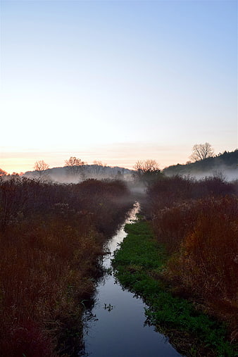 Misty Autumn Stream at Sunrise with Foggy Landscape