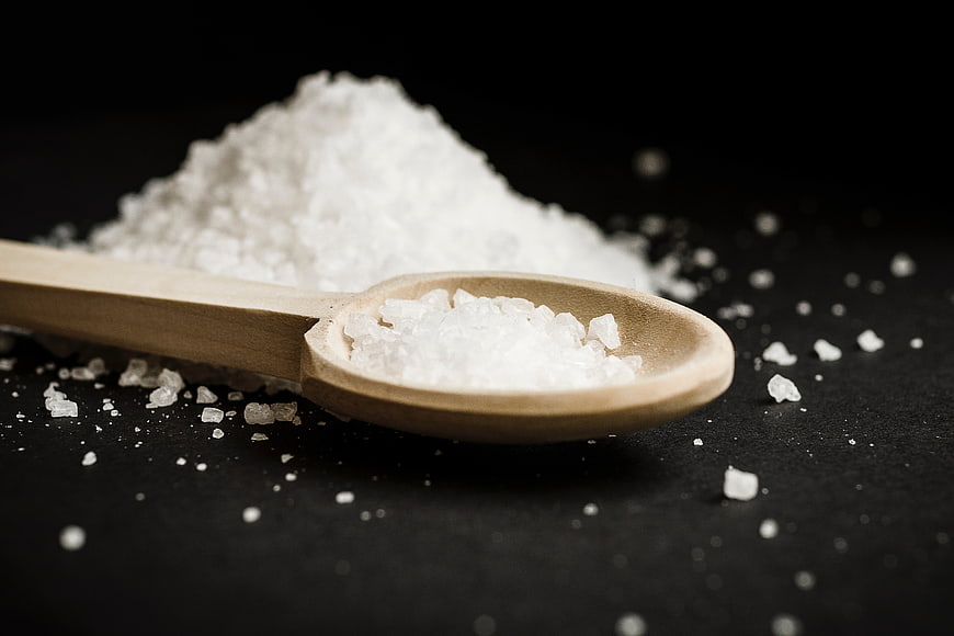 Coarse Sea Salt on Wooden Spoon with Black Background