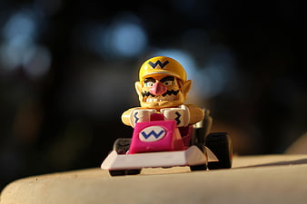 Wario toy figure in pink go-kart with shallow depth of field