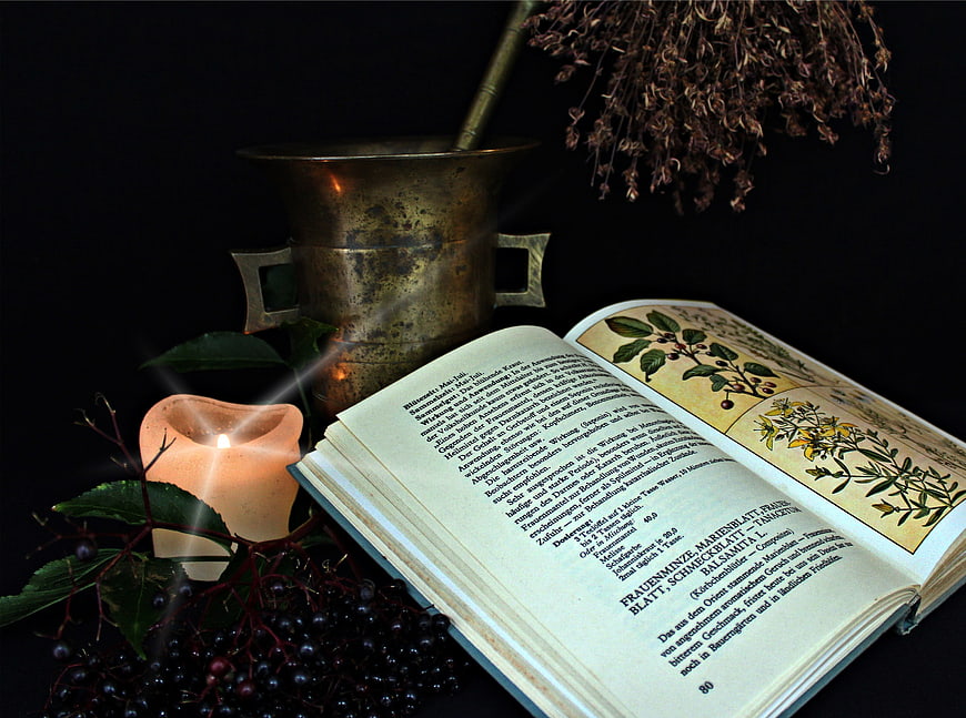 Vintage Herbal Medicine Book With Candle, Mortar, And Dried Herbs