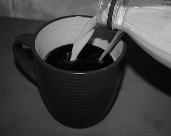Pouring Milk into Black Coffee Mug in Black and White