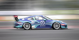 Blue Porsche 911 GT3 Cup race car speeding on track