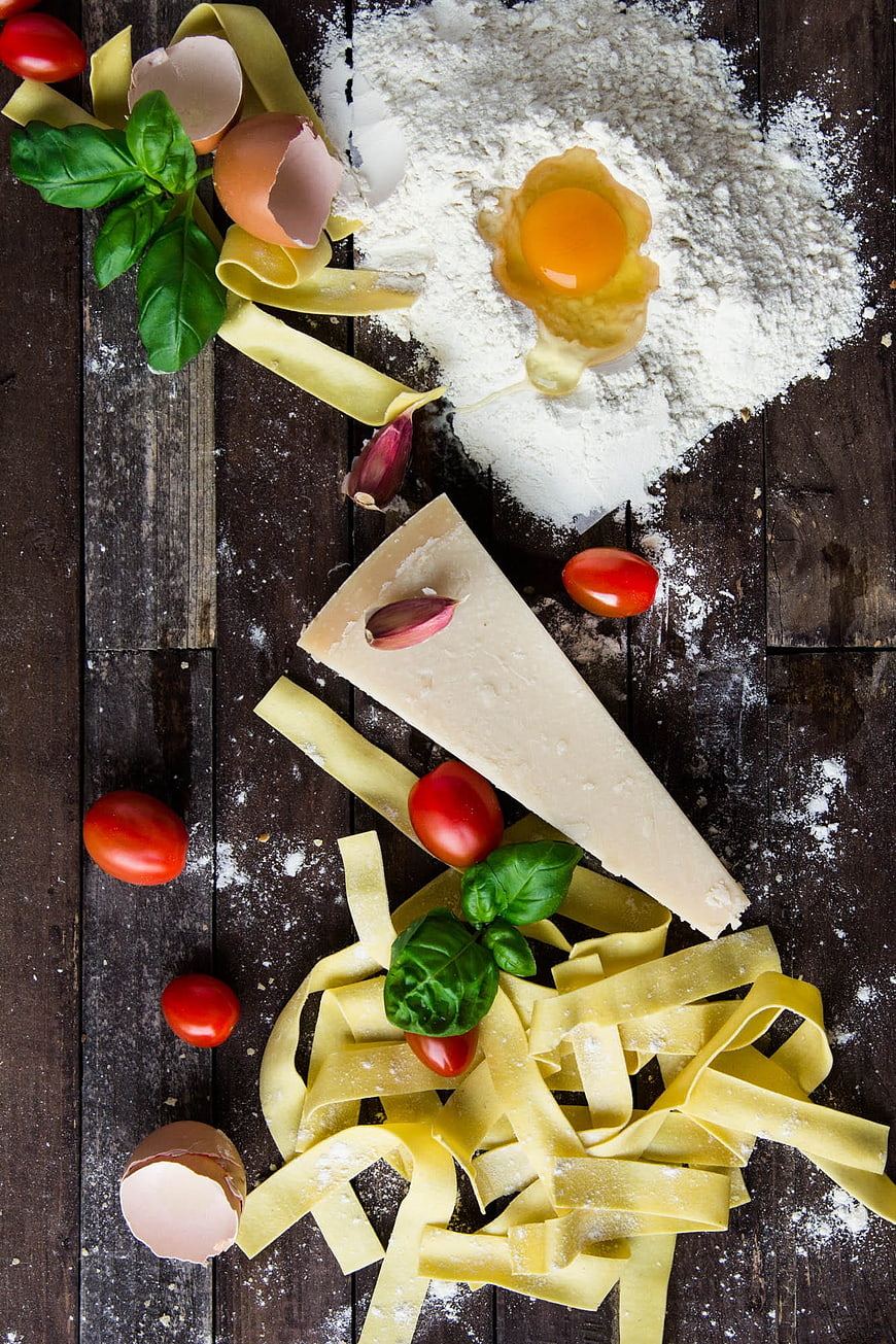 Fresh pasta ingredients flat lay on dark wood