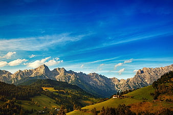 Scenic Alpine Mountain Landscape with Green Hills and Blue Sky