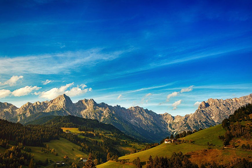 Scenic Alpine Mountain Landscape with Green Hills and Blue Sky