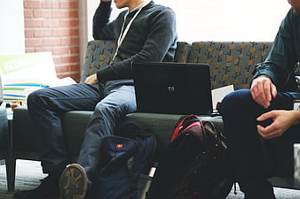 Two Men Working On Laptop In Modern Office Lounge