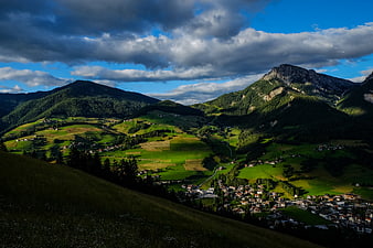 Scenic Alpine Valley with Village and Dramatic Clouds