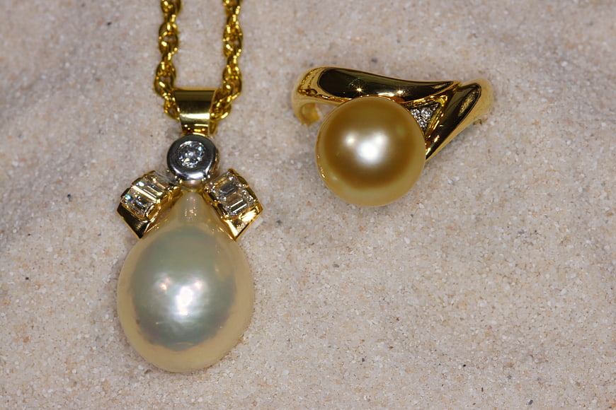 Gold Pearl Necklace and Ring on Sand