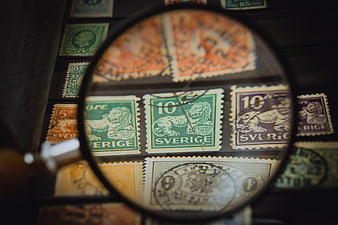 Vintage Swedish postage stamps viewed through a magnifying glass