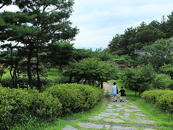 Mother and son walking on stone path in Korean garden