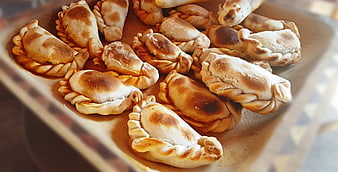 Freshly baked traditional empanadas on a wooden board