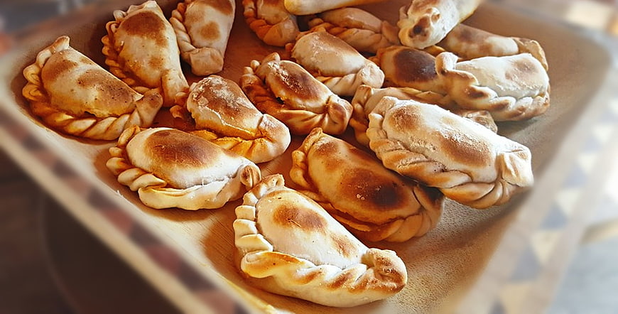 Freshly baked traditional empanadas on a wooden board