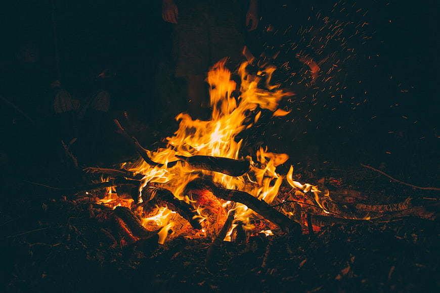 Campfire at Night with Sparks and Silhouette