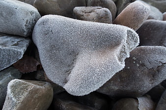 Close-up of frost-covered grey stones in winter
