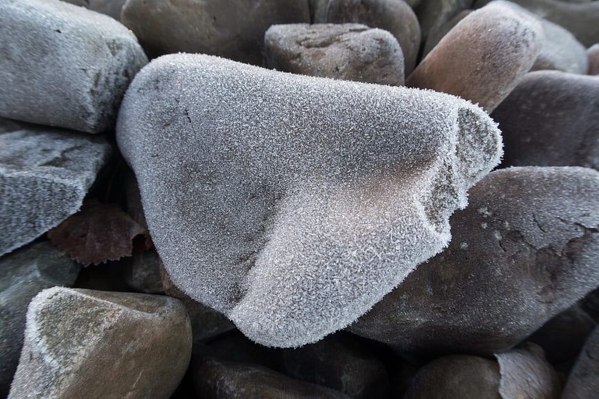 Close-up of frost-covered grey stones in winter