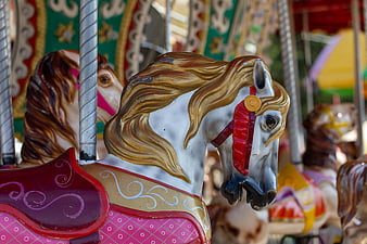 Close-up of a white carousel horse with golden mane