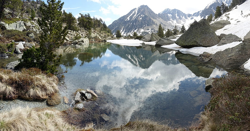 Alpine Lake with Mountain Reflections and Snow Patches