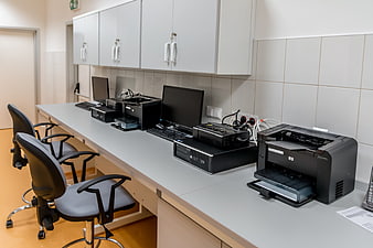 Modern office workspace with computers and printers