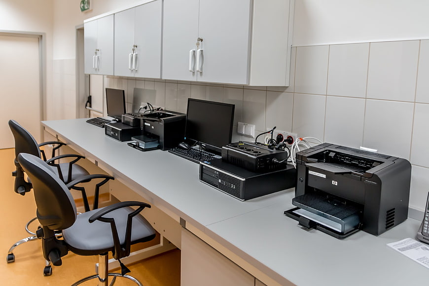 Modern office workspace with computers and printers